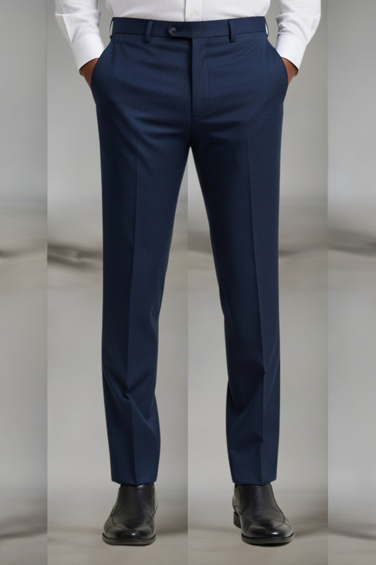 Navy blue dress pants worn with a white shirt and black shoes on a neutral background