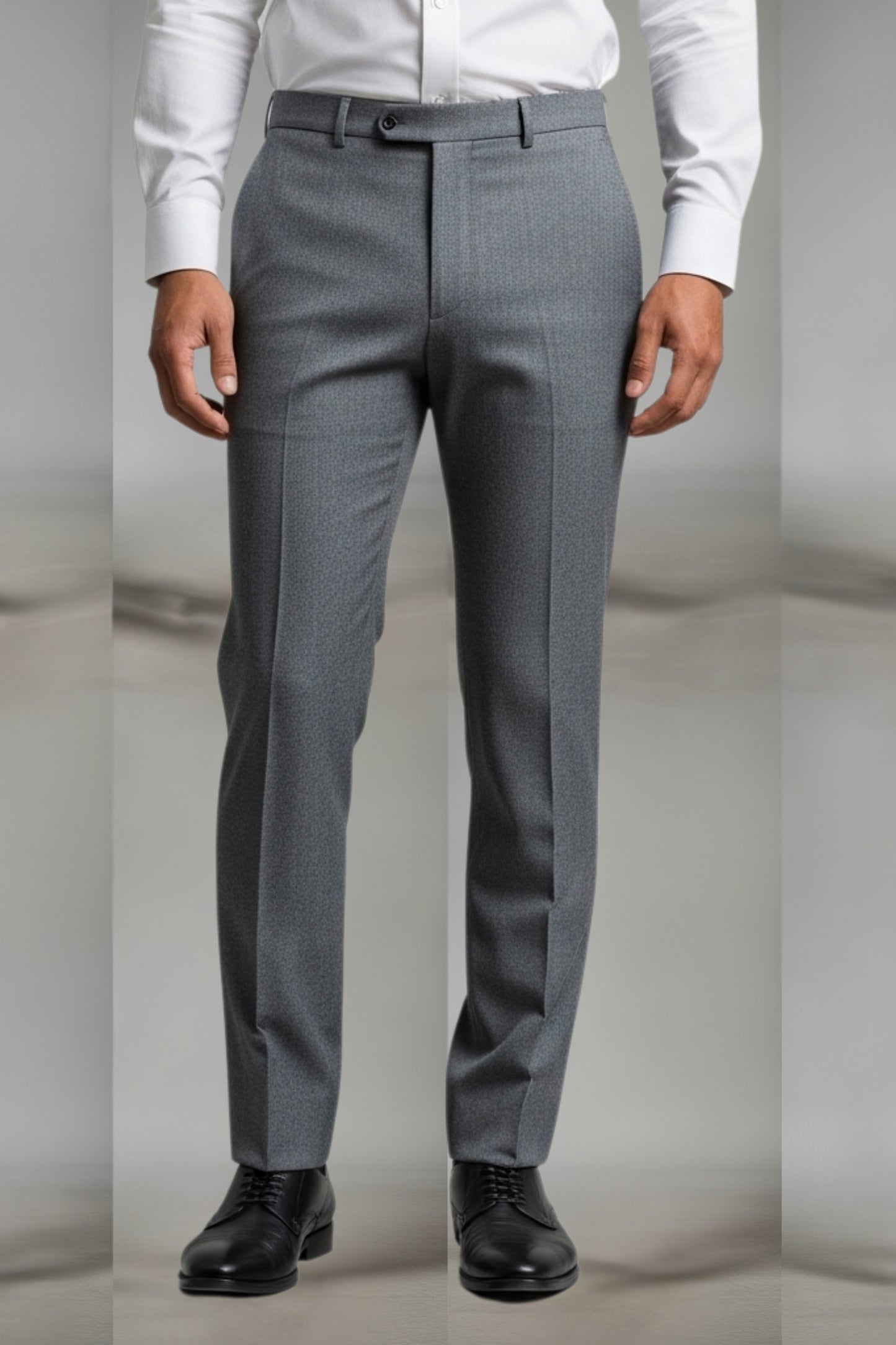 Gray dress pants worn with a white shirt and black shoes on a neutral background