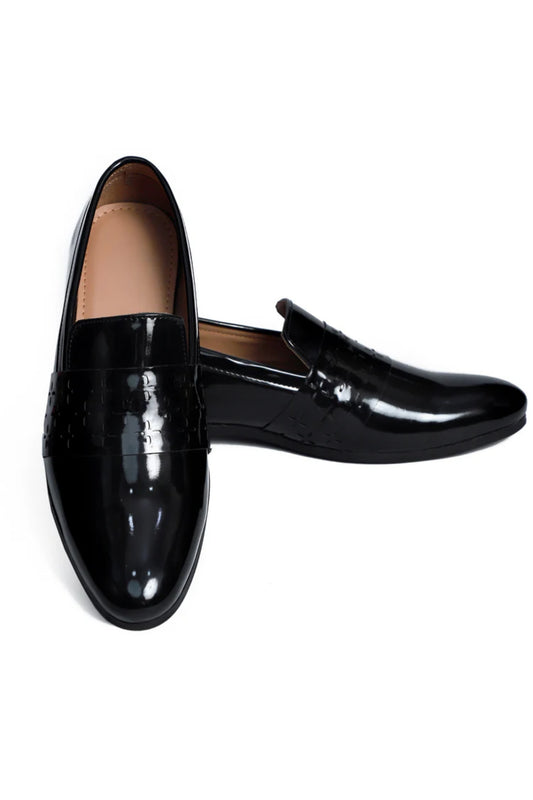 Pair of black patent leather loafers on a white background