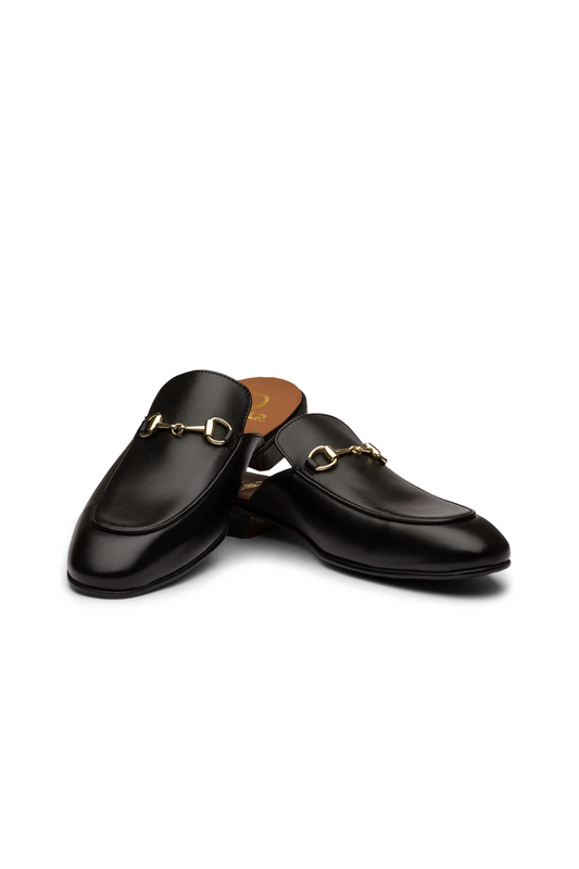 Pair of black loafers with gold accents on a white background