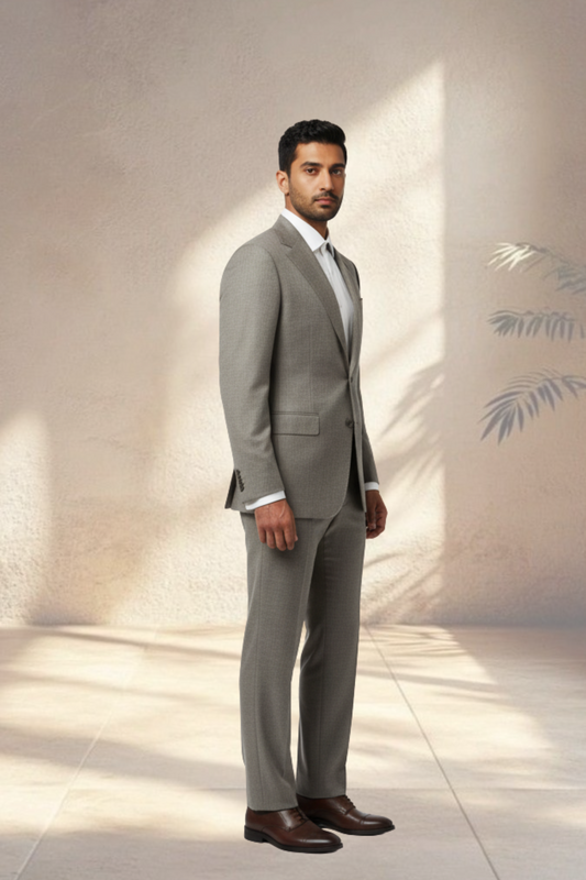 Man wearing a gray suit standing against a neutral background
