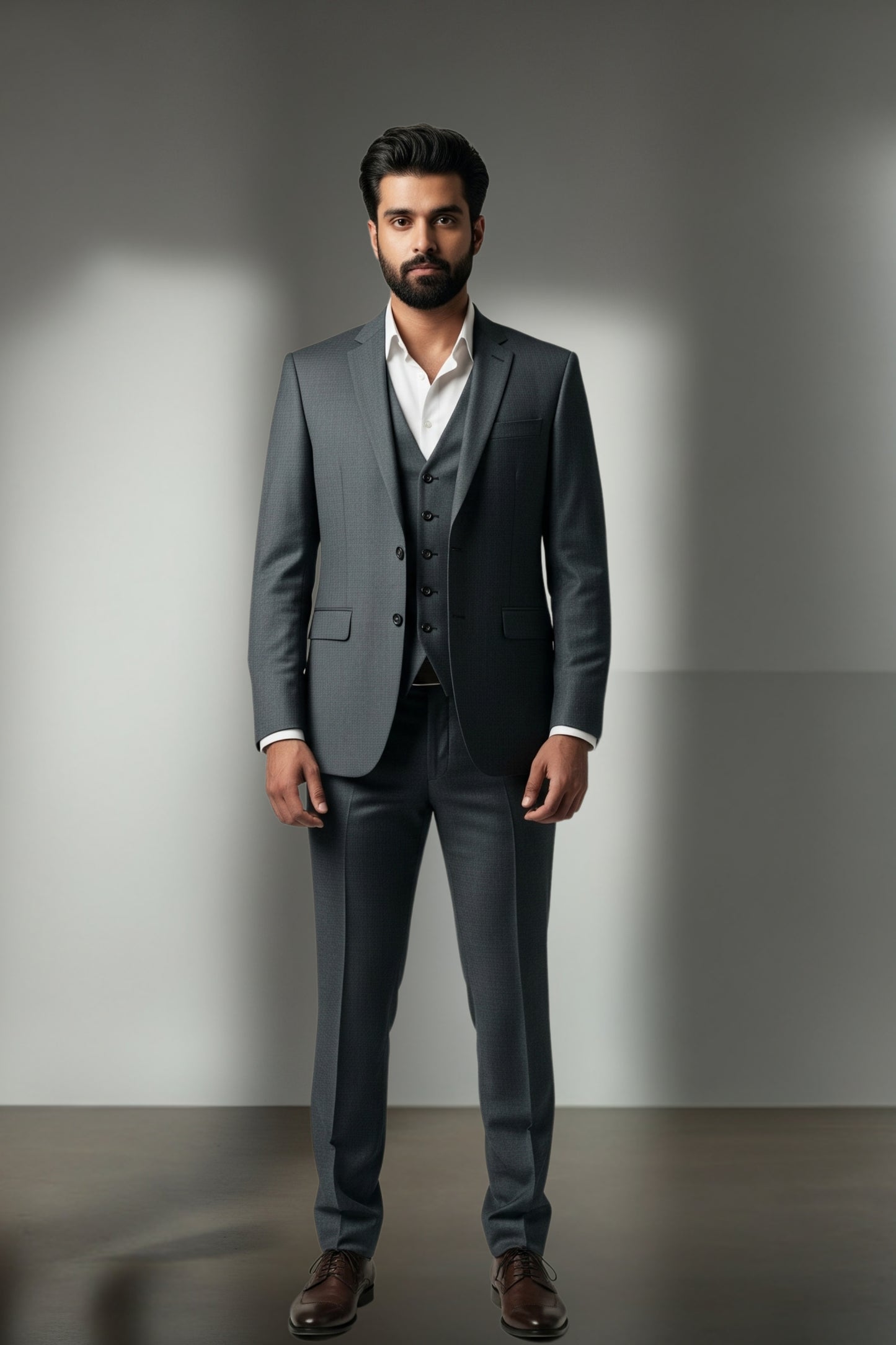 Man wearing a gray suit standing against a plain background