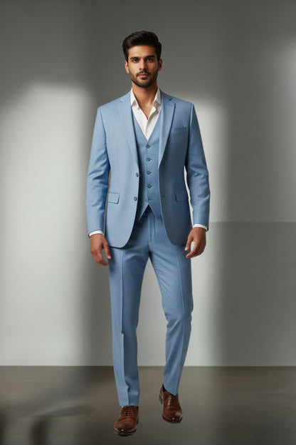 Man wearing a light blue suit with a white shirt and brown shoes on a gray background