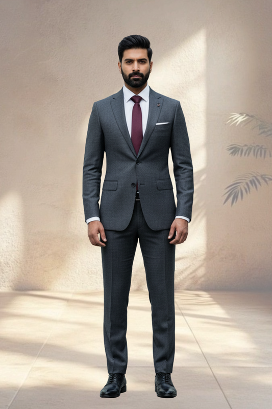 Man wearing a gray suit with a red tie against a neutral background