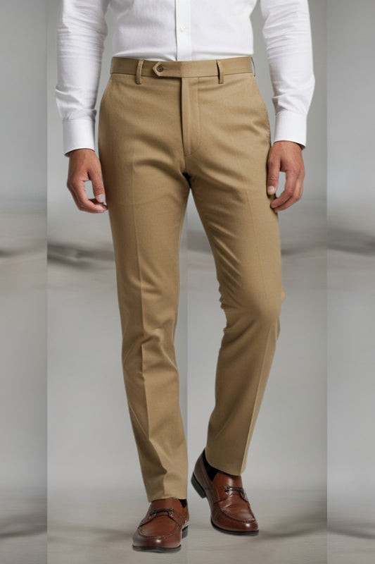 Beige pants worn with a white shirt and brown shoes on a plain background