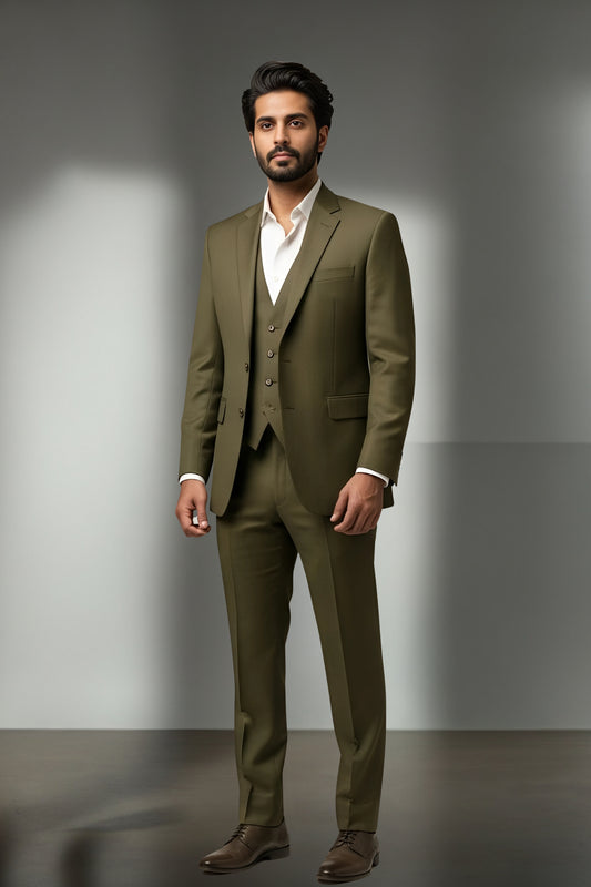 Man wearing a green suit standing against a gray background