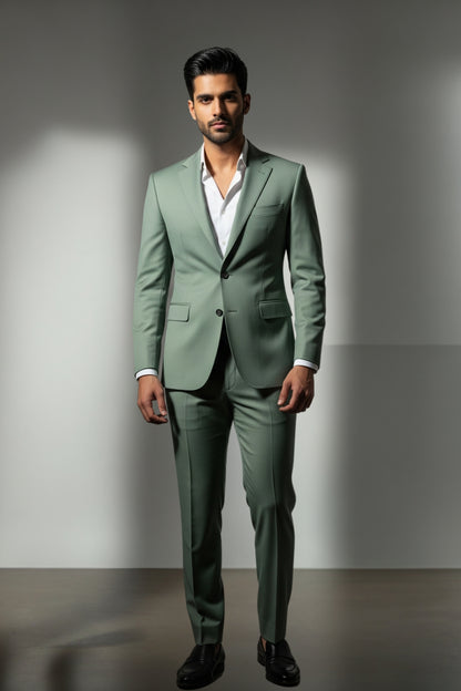 Man wearing a green suit with a white shirt against a gray background