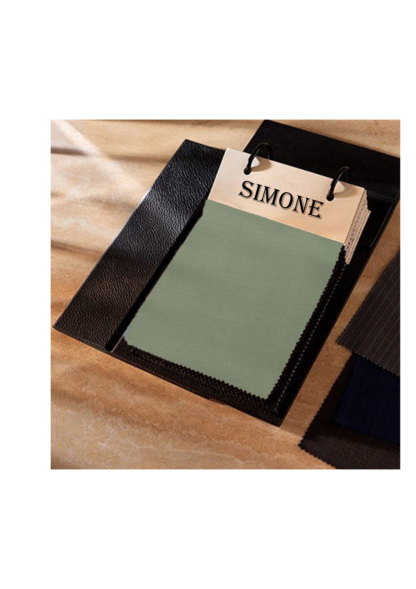 Green fabric sample with a 'SIMONE' label on a wooden surface