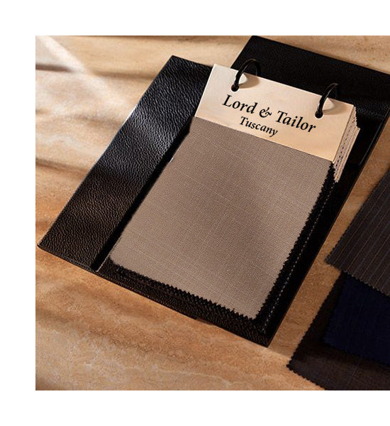 Fabric swatch book with brown fabric sample and 'Lord & Tailor Tuscany' label on a wooden surface.