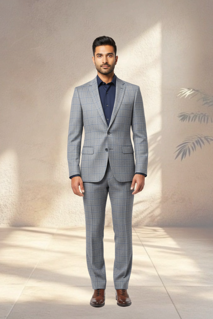 Man wearing a gray checkered suit with a blue shirt against a neutral background