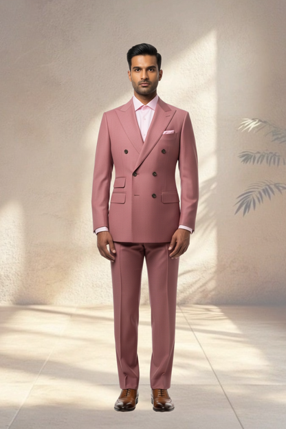 Man wearing a pink suit with a white shirt and brown shoes against a neutral background