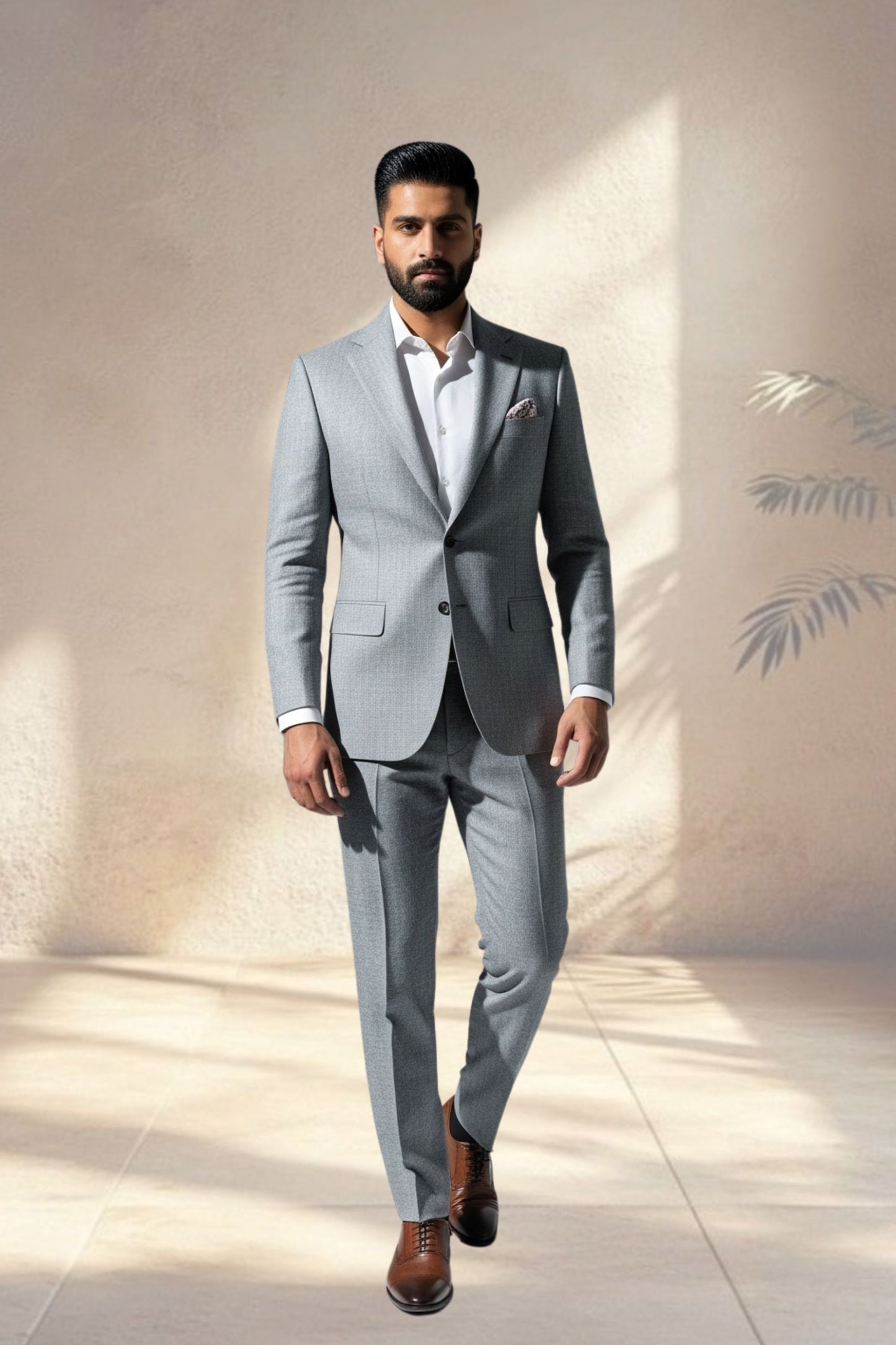 Man wearing a gray suit with a white shirt and brown shoes against a neutral background